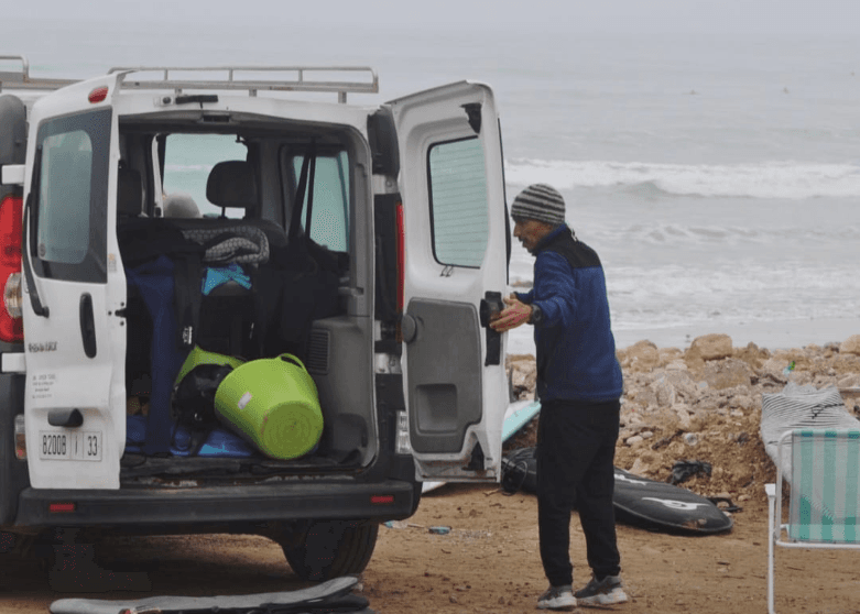 Ben preparing surf equipment beside the van before a guided surf day