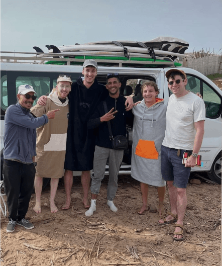 Ben with a group of surf guests beside the van