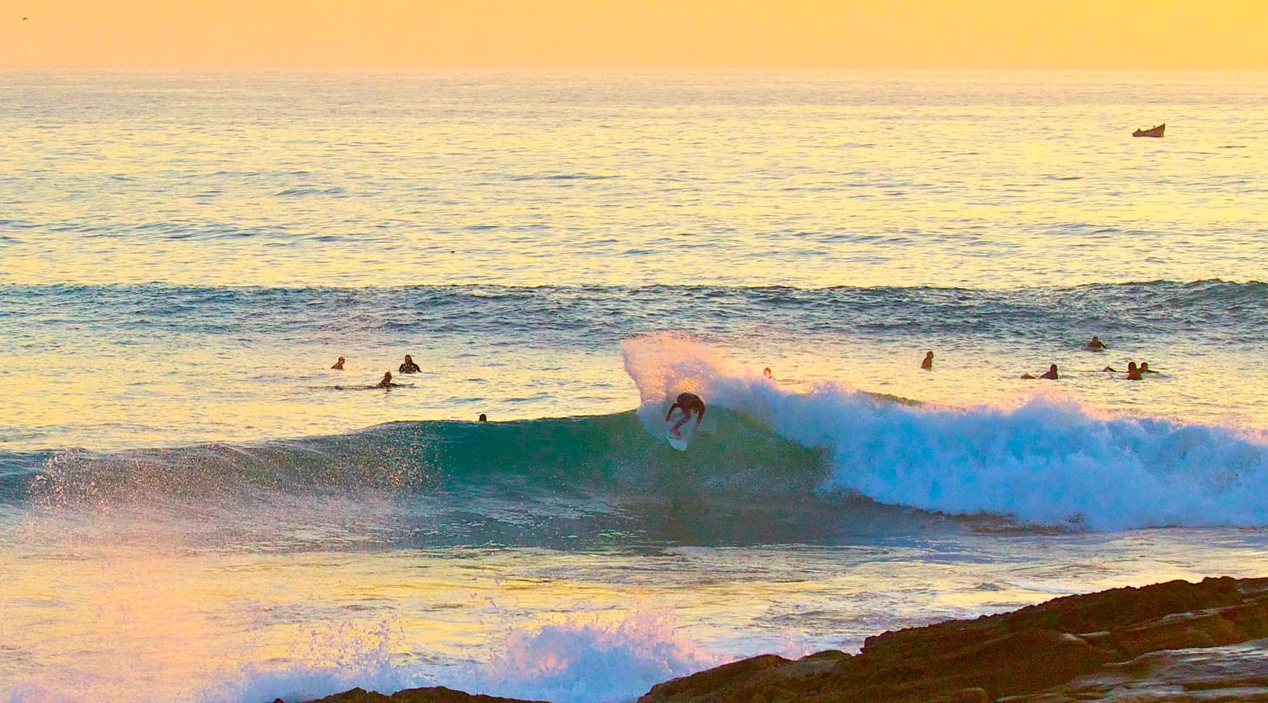 Surfer riding Anchor Point at sunset near Taghazout Morocco
