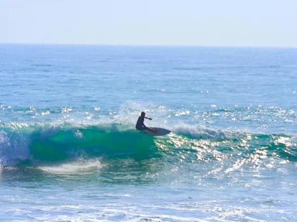 Surfer riding a smaller wave at La Source Taghazout